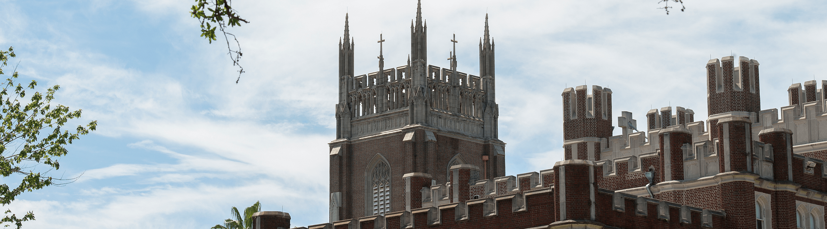 Image of tower of Marquette Hall against blue sky, 3/4 view