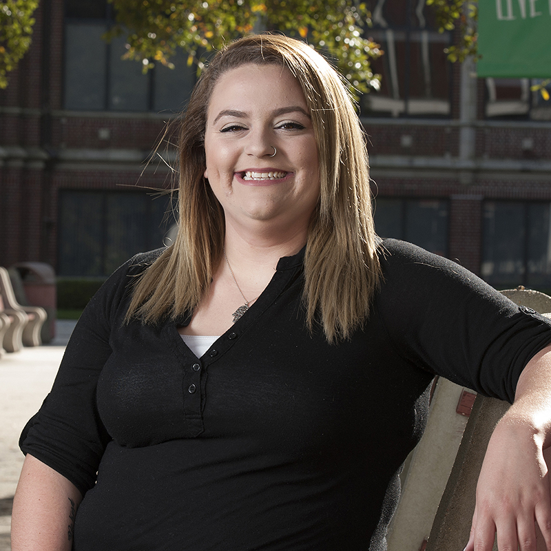 Student Jordan Pedalino sitting on bench on campus