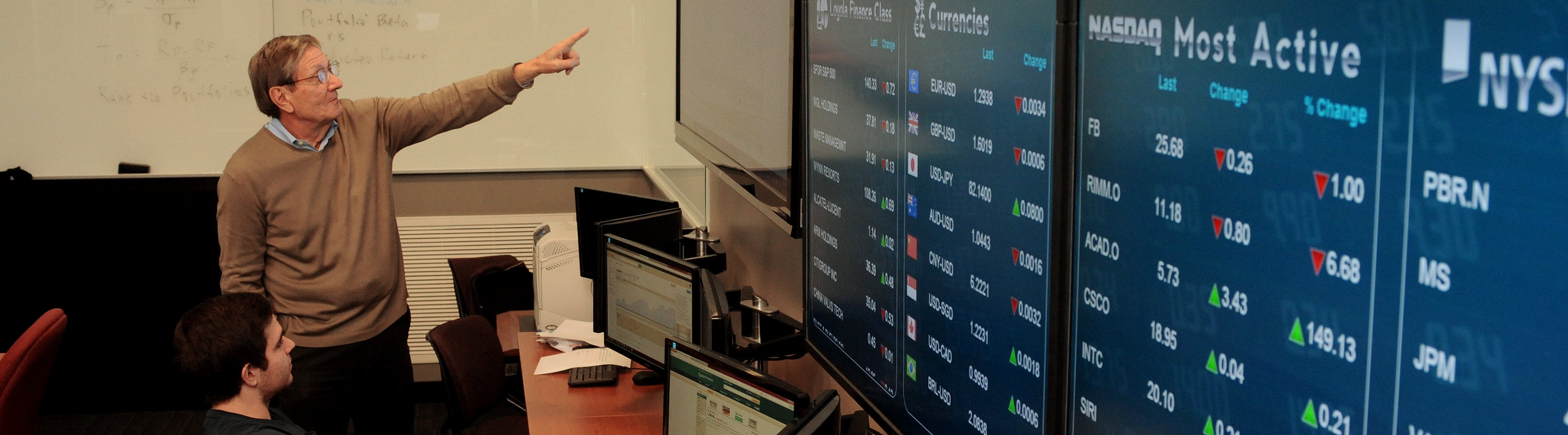 Professor pointing at stock display