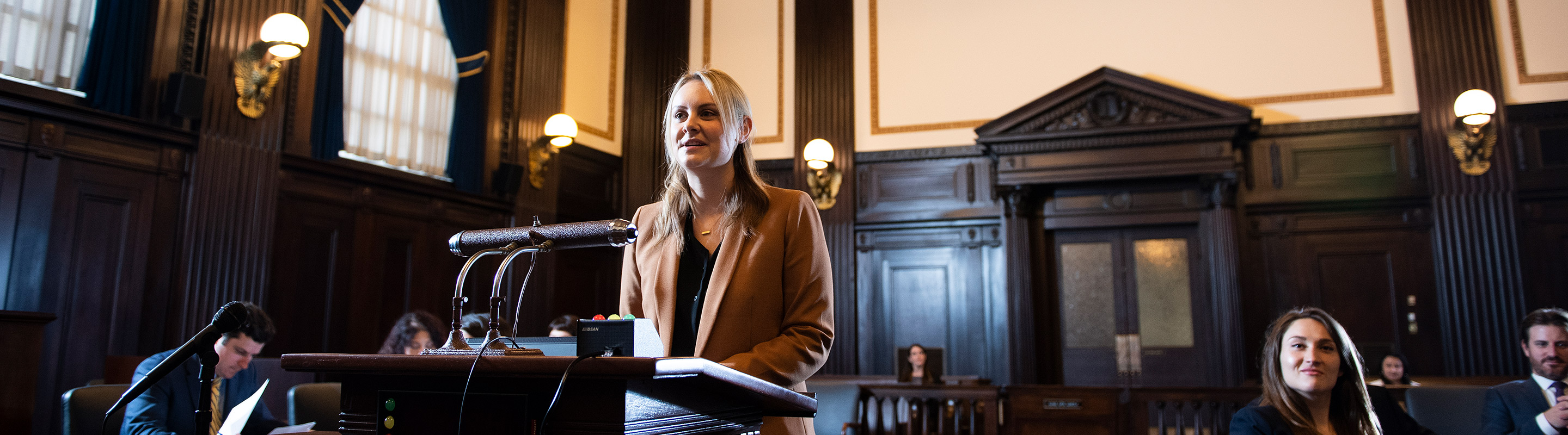 Woman standing at podium of courthouse