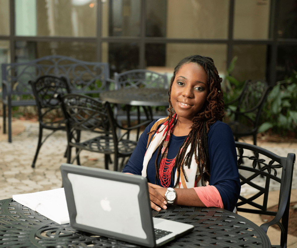 Online student working on her laptop outside.