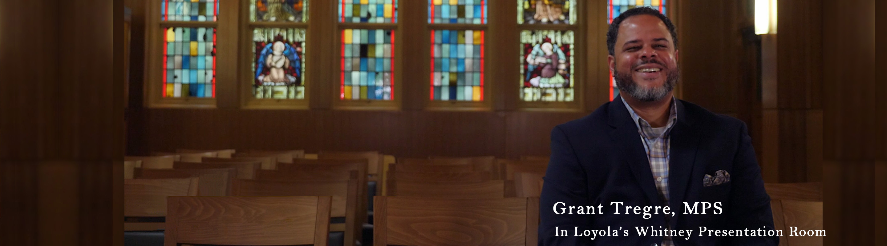 on-campus master of pastoral studies student in front of a stained glass window.