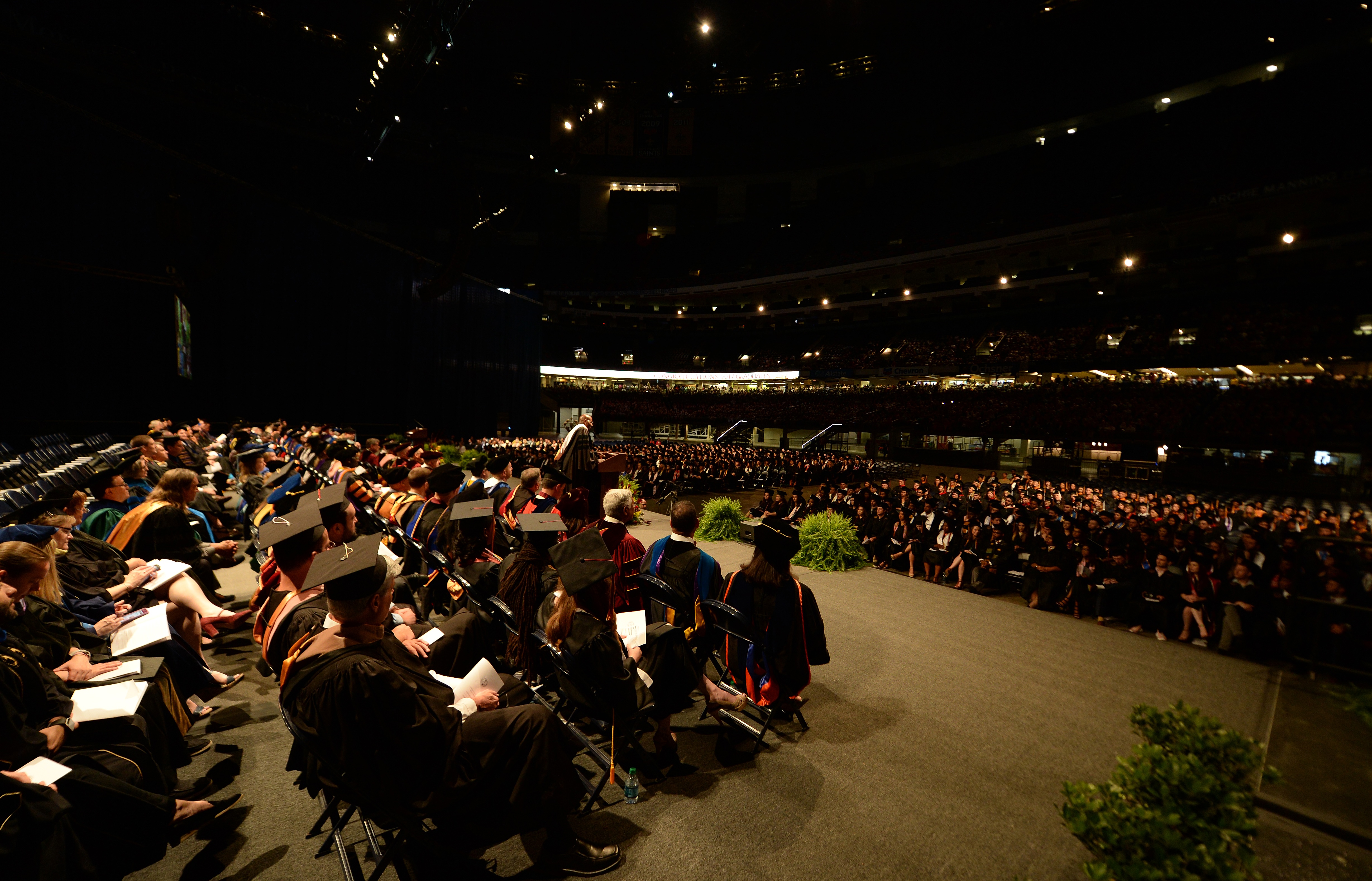 Students in graduation robes sitting during commencement