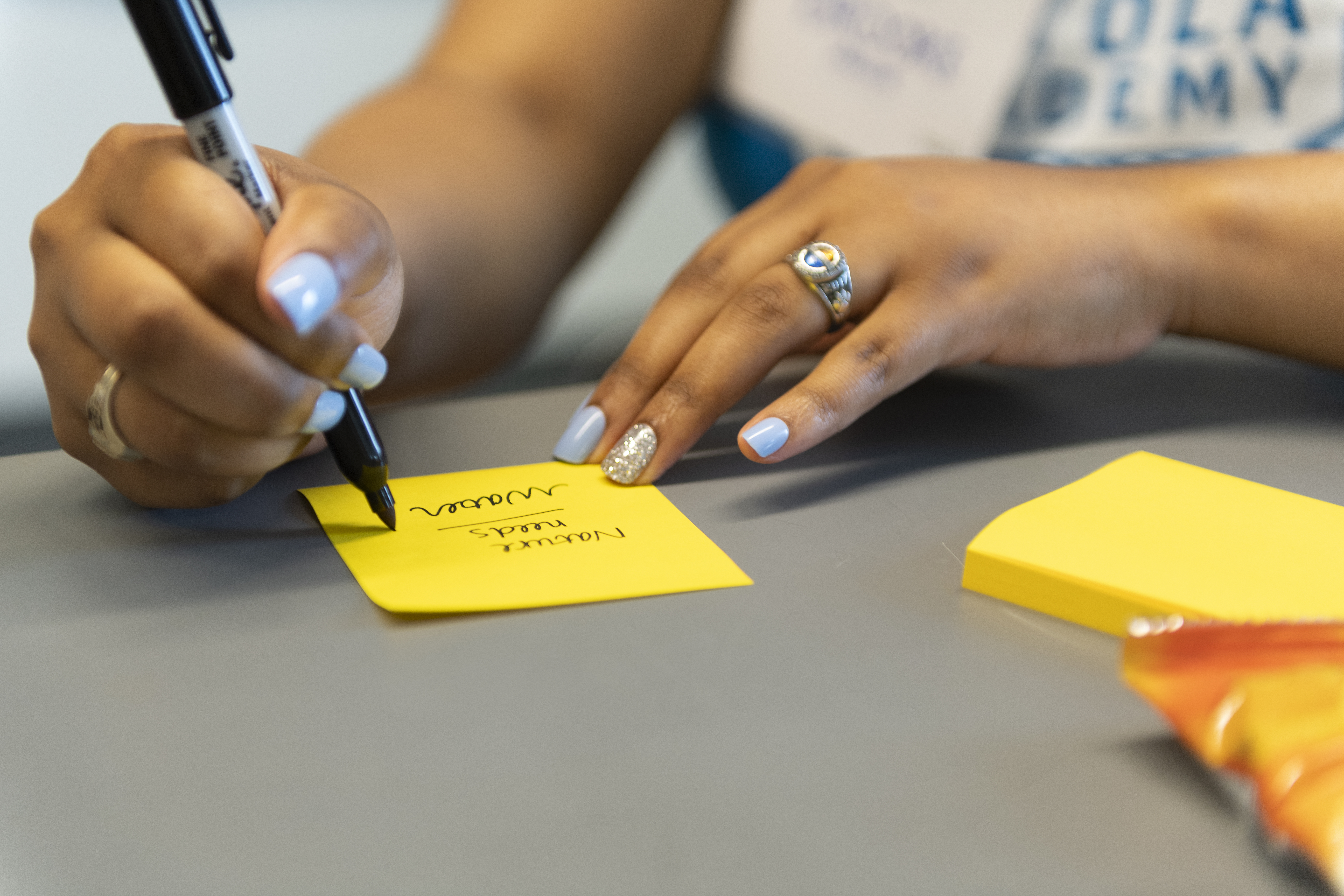 Student writing on a sticky note